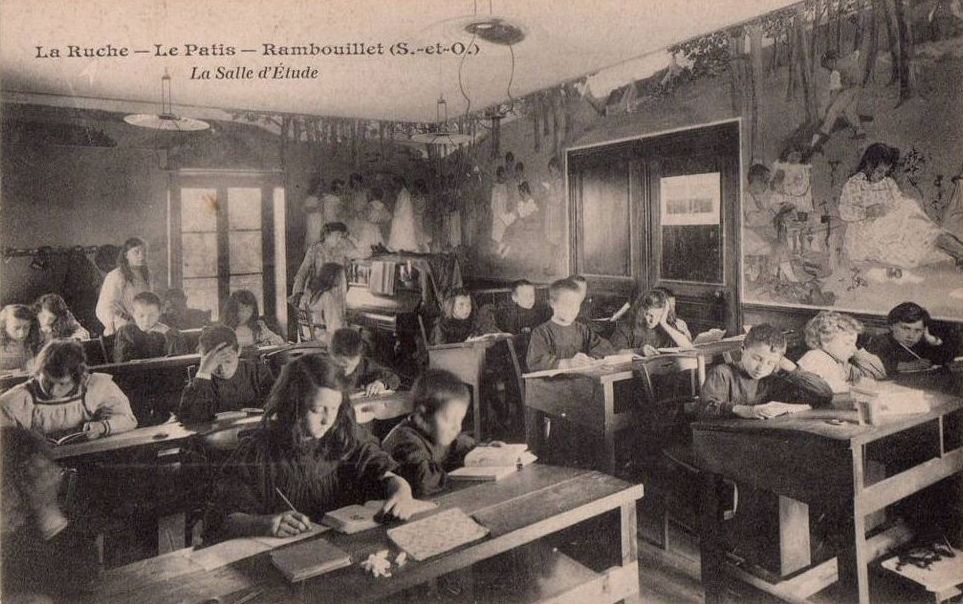 Carte postale éditée par l'imprimerie de la Ruche de Rambouillet : les enfants sont dans la salle de classe unique de l'école.